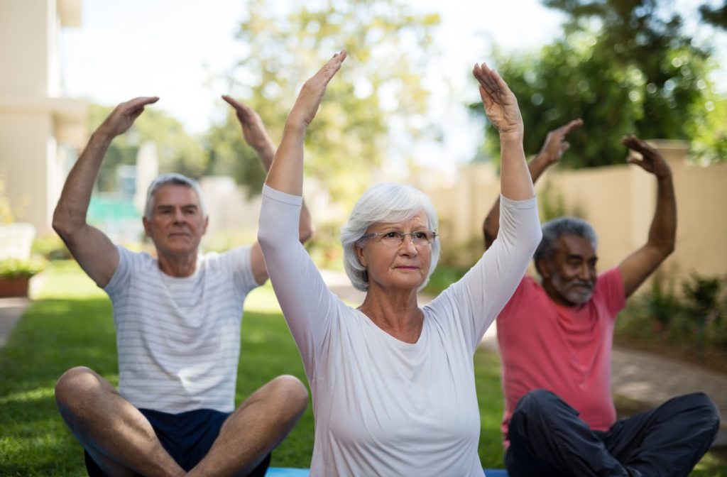 Seniors participating in yoga outside in the communities park.